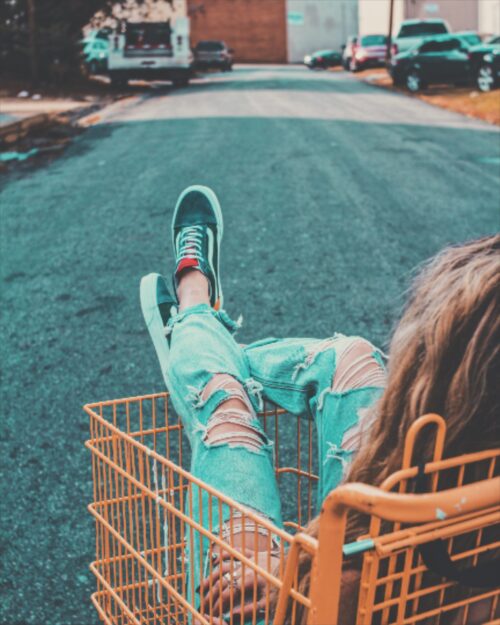 orange shopping cart with woman sitting inside