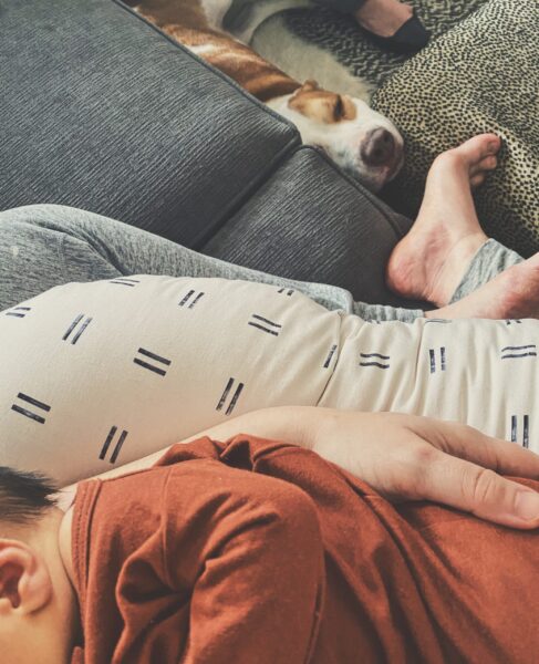 Feeding baby in lap with dog on floor
