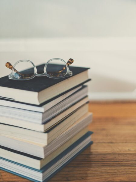 Stack of best period and menstrual cyclebooks with glasses on top