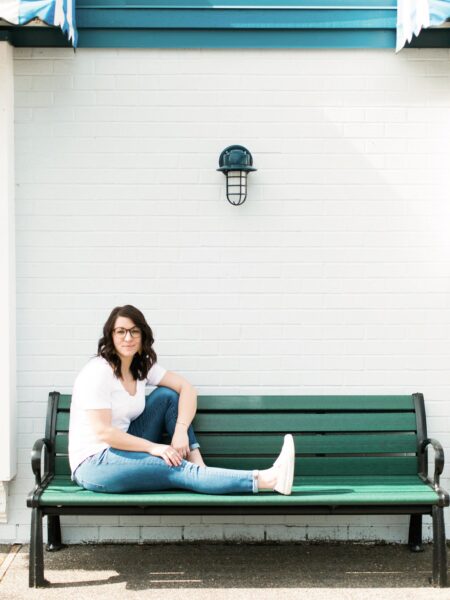 Amanda Davis, pelvic rehab therapist, sitting on green bench