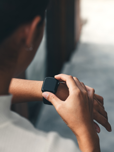 woman looking at smart watch cons
