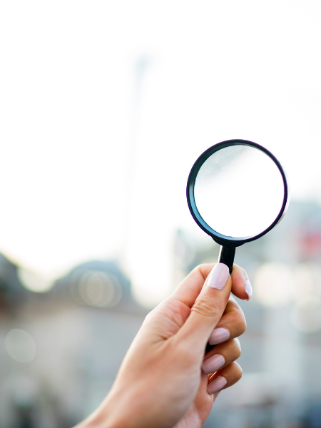 woman's hand holding magnifying glass