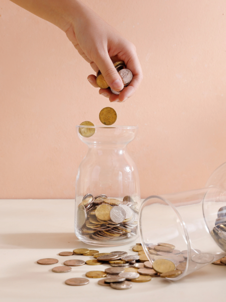 Hand dropping money in jar
