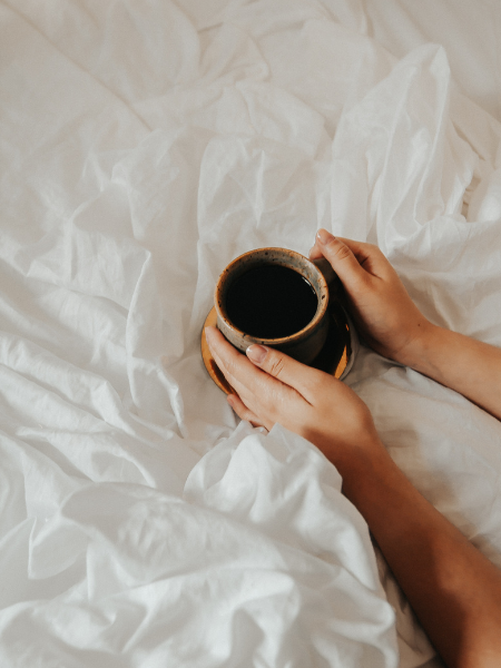 Hands holding coffee after waking up 15 minutes earlier